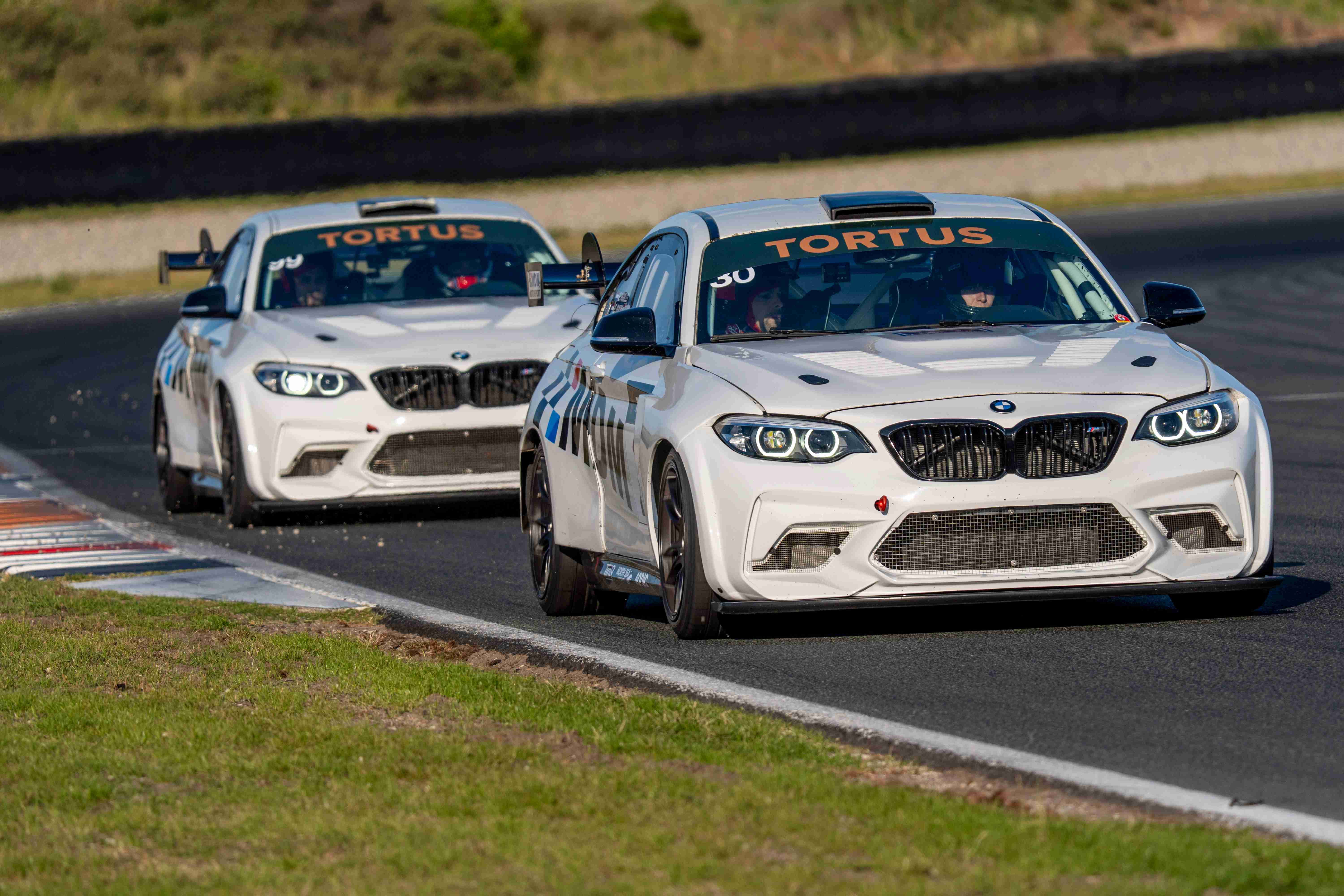 BMW racing cars in close formation on track