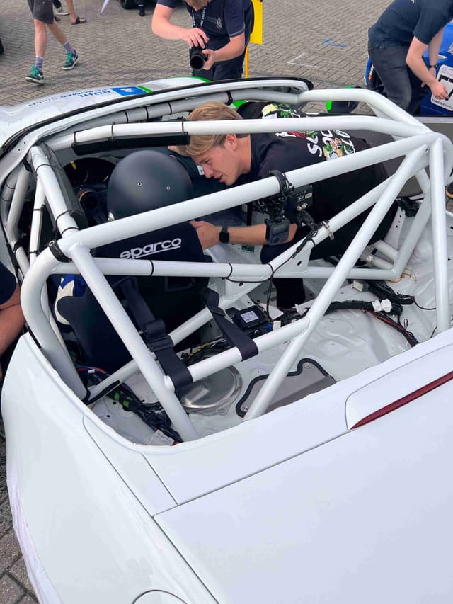 Joshua preparing race car with roll cage