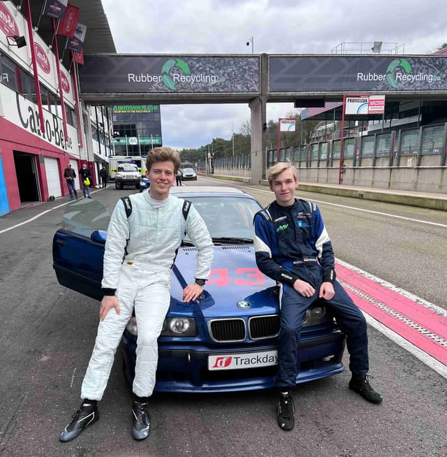 Young drivers with BMW race car at circuit