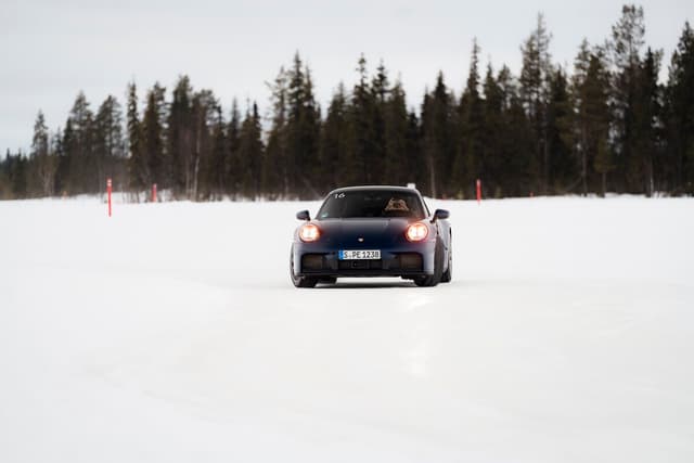 Porsche 911 on snow track with headlights